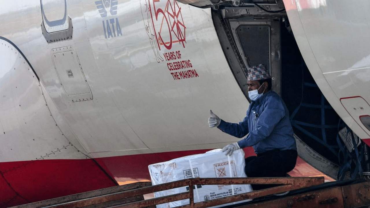 A worker gestures as he unloads a box of Covishield, AstraZeneca-Oxford's Covid-19 coronavirus vaccine made by India's Serum Institute, from an aircraft upon its arrival from India at the Tribhuvan International Airport in Kathmandu on January 21, 2021. Credit: AFP Photo