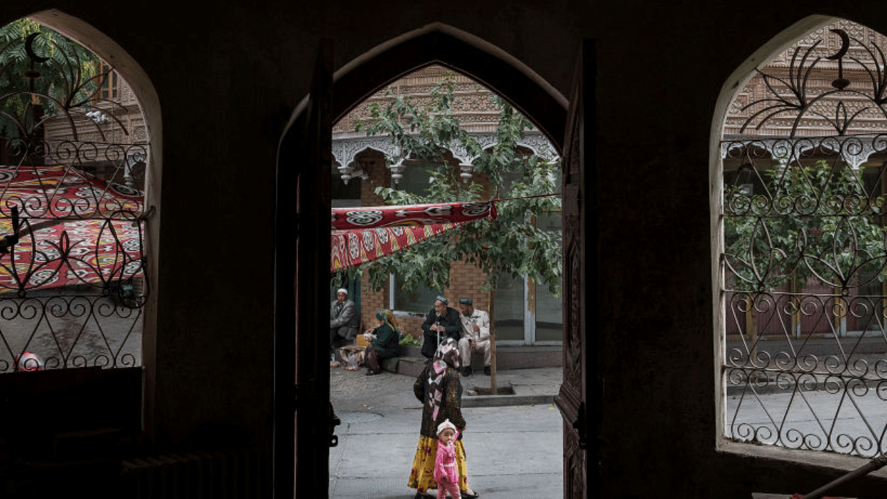  An ethnic Uyghur woman walks by the closed Islamic school on July 1, 2017 in the old town of Kashgar, in the far western Xinjiang province, China. Credit: Getty Images