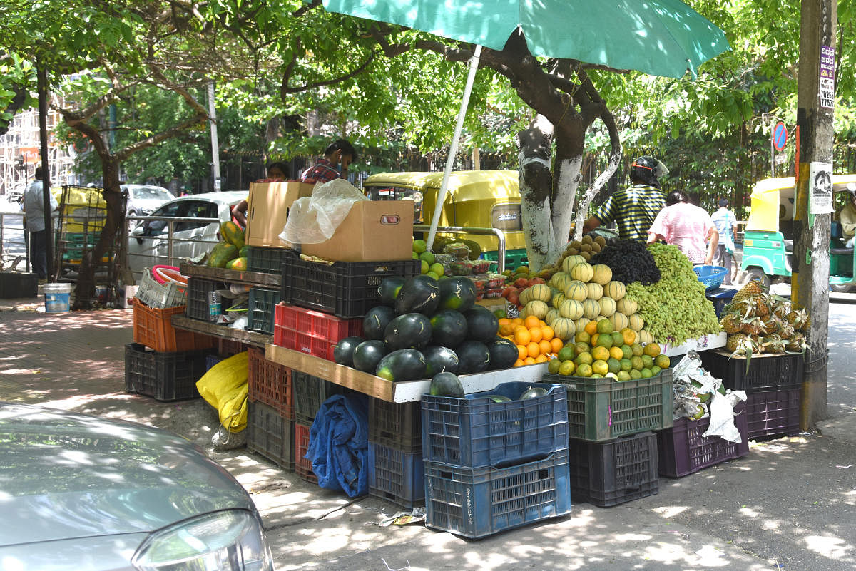 Residents say fruit and vegetable vendors have set up permanent shops on the footpaths. DH Photos by SK Dinesh