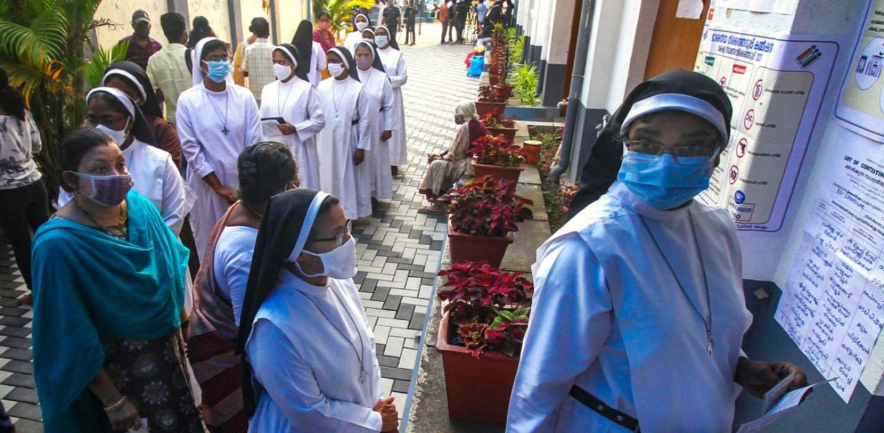 Catholic nuns wait outside a polling booth to cast votes for Kerala Assembly elections, in Kochi, Tuesday, April 6, 2021. Credit: PTI Photo