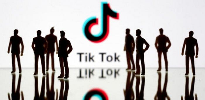 Silhouettes in front of TikTok logo. Credit: Reuters Photo