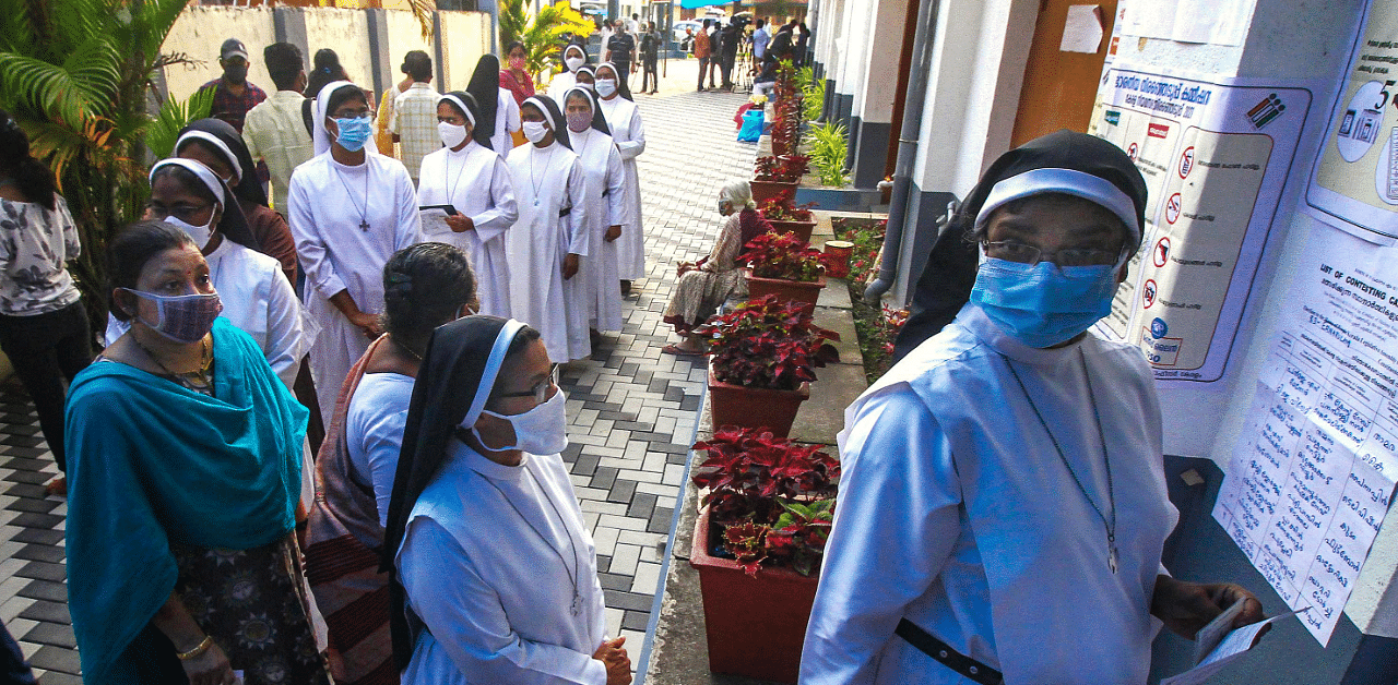 Catholic nuns wait outside a polling booth to cast votes for Kerala Assembly elections, in Kochi. Credit: PTI Photo