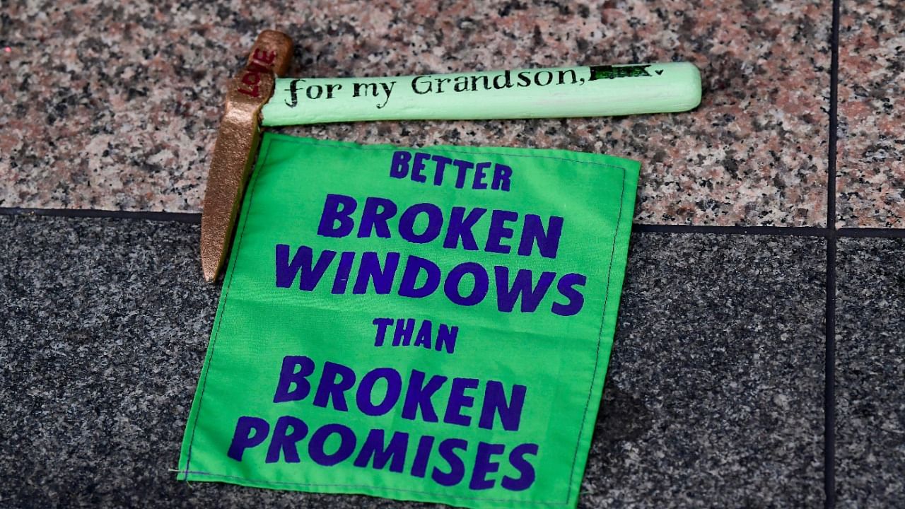 The activists from the Extinction Rebellion group carried placards with slogans such as "Better Broken Windows than Broken Promises" Credit: Reuters Photo