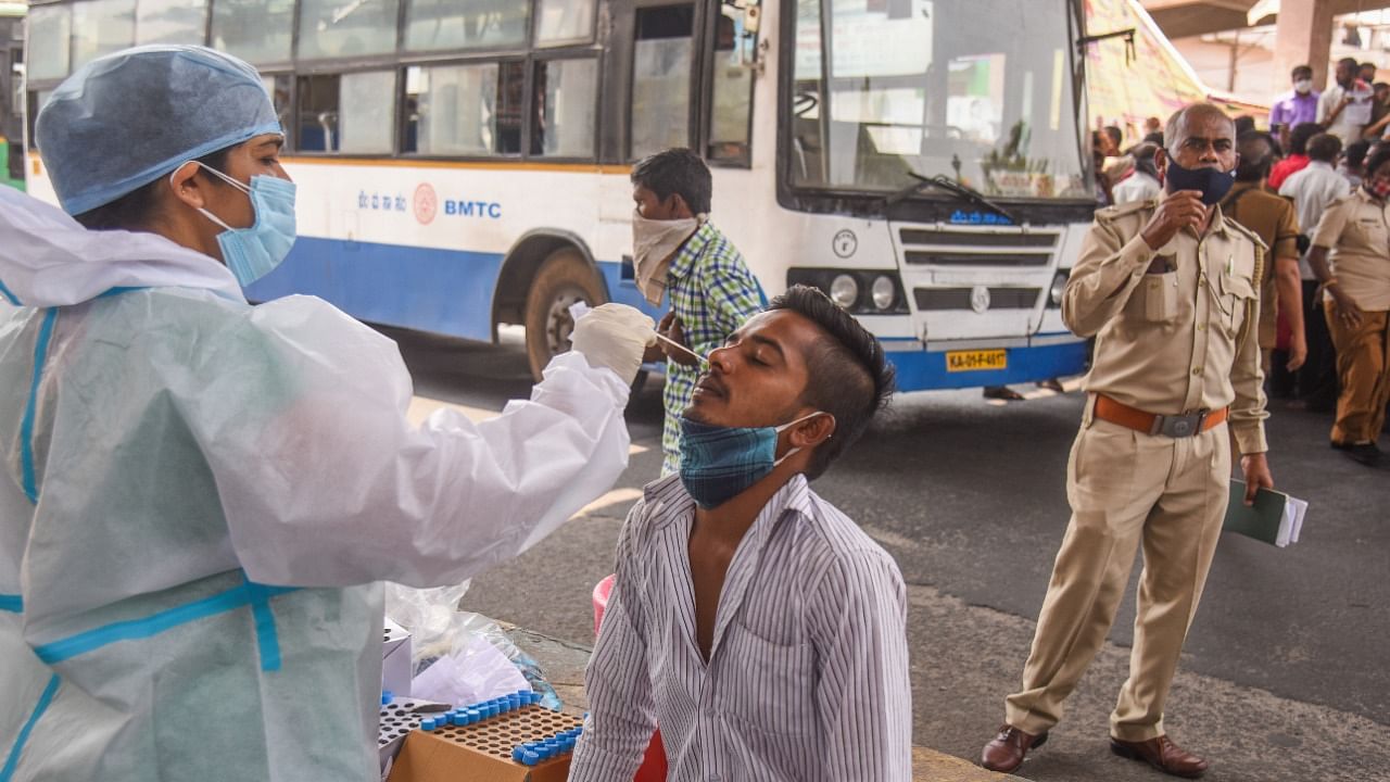 Health staff collect a nasal swab sample from people at free Covid 19 Corona Virus test camp set up by BBMP at Kempegowda BMTC bus station, Majestic in Bengaluru. Credit: DH Photo/S K Dinesh