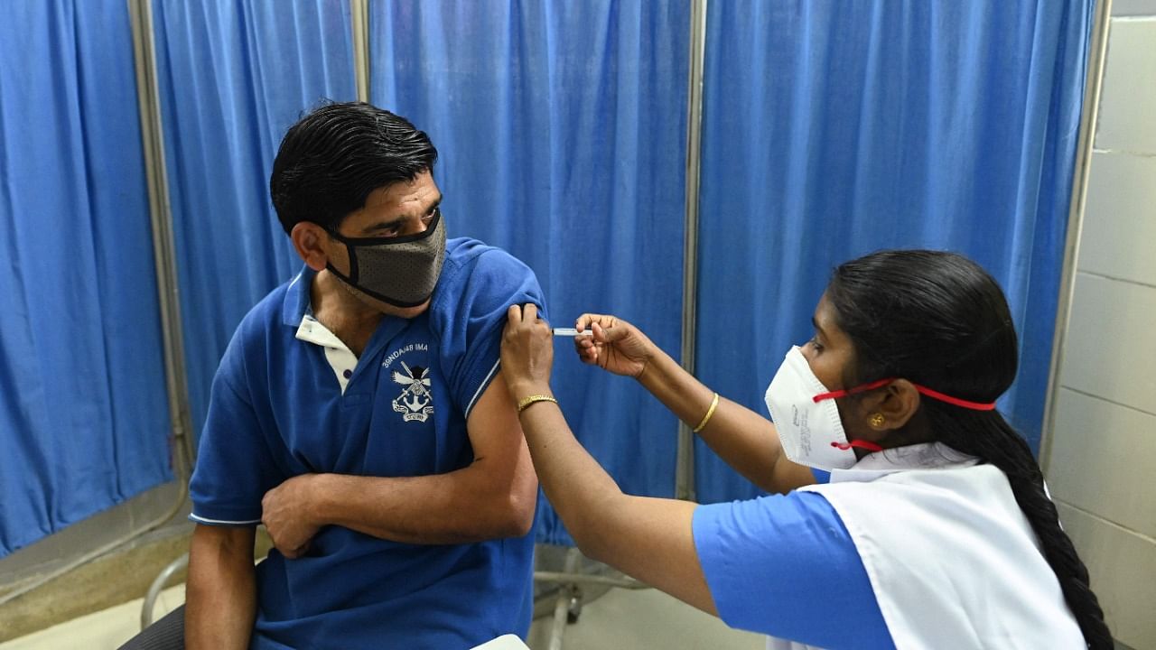 A medical worker inoculates a man with the Covaxin Covid-19 coronavirus vaccine, at a health centre in New Delhi. Credit: AFP.