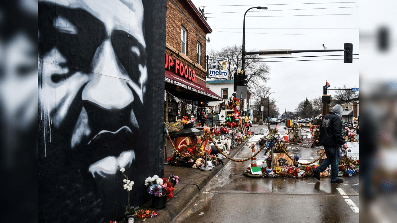 In this file photo taken on March 10, 2021, a man walks near the makeshift memorial of George Floyd before the third day of jury selection begins in the trial of former Minneapolis Police officer Derek Chauvin who is accused of killing Floyd, in Minneapolis, Minnesota. Credit: AFP File Photo