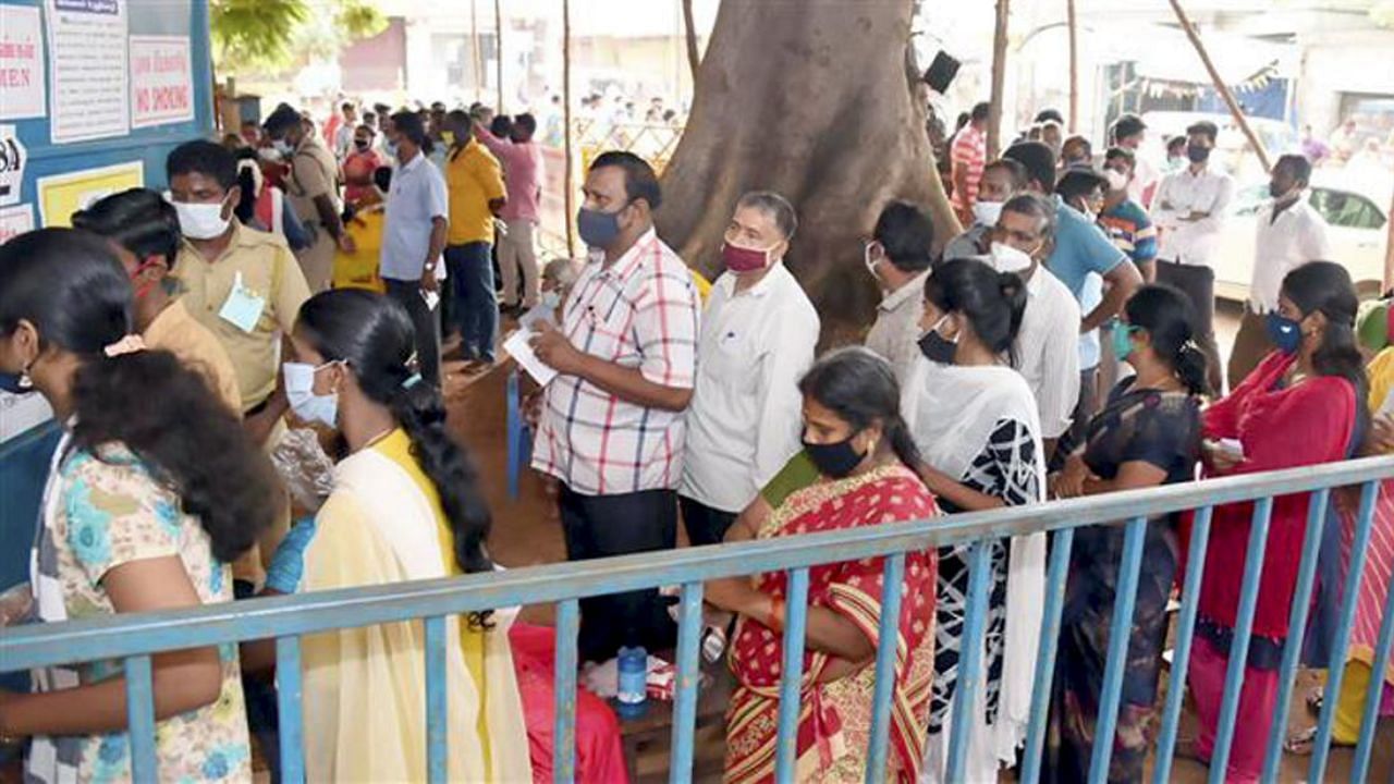 Voters stand in a queue to cast their votes, at a polling booth, during the Puducherry Assembly Election, in Pudupet, Puducherry. Credit: PTI photo. 