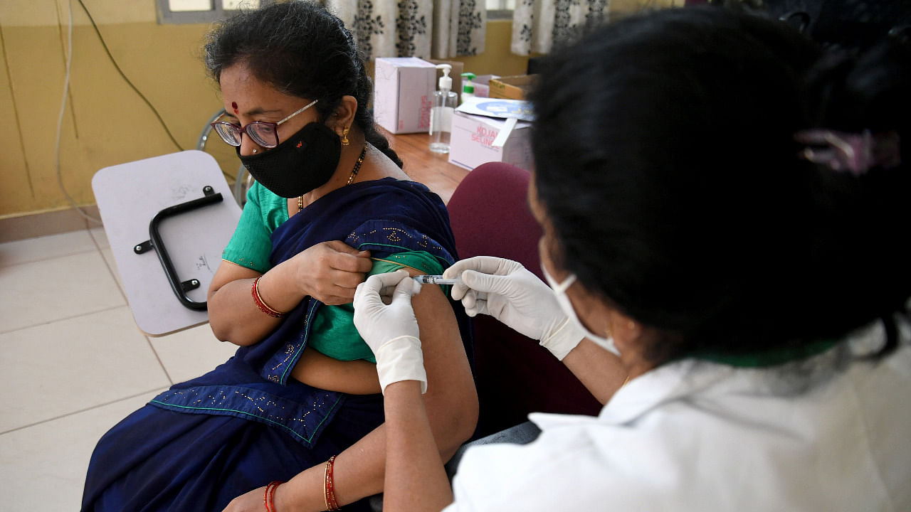 A healthcare worker vaccinates a woman against Covid-19 at KC General Hospital in Bengaluru. Credit: DH Photo