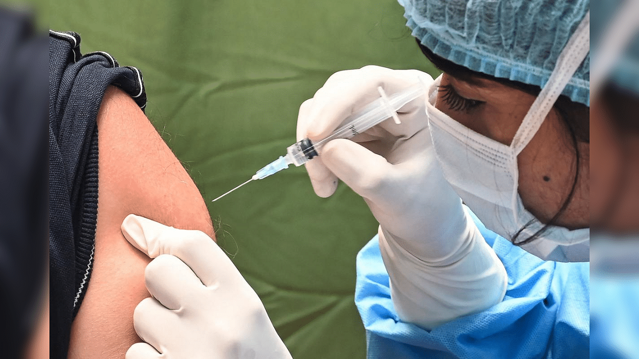 An elderly man gets inoculated by a medical staff with the Covishield vaccine as part of the nationwide Covid-19 coronavirus vaccination drive at the SRCC hospital in Mumbai on March 19, 2021 as coronavirus cases continue to increase. Credit: AFP Photo