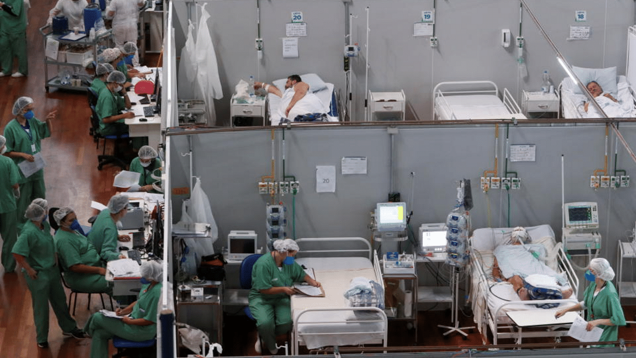 Healthcare staff work next to patients suffering from the coronavirus disease (COVID-19) at a field hospital set up at Dell'Antonia sports gym in Santo Andre, on the outskirts of Sao Paulo, Brazil April 7, 2021.  Credit: Reuters Photo