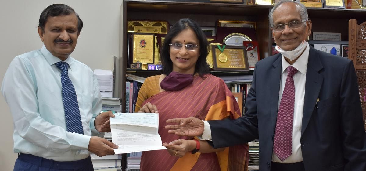 Dr K P Gopalakrishna, Chairperson, NPS, and Dr Bindu, Director, NPS Group of Institutions, handed over a cheque for Rs 15 lakh to Dr C N Manjunath, Director of SJICR. Credit: DH Photo
