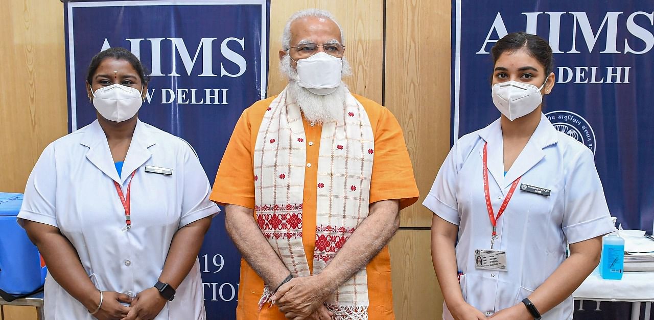 Narendra Modi posing for a photo with the nurses who administered his vaccination. Credit: PTI Photo