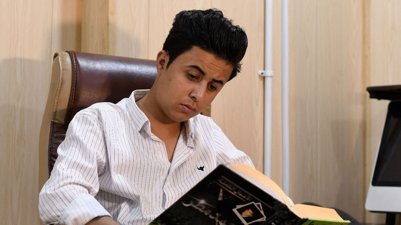 Hussein, a young Iraqi activist born in 2000, reads a book in his hometown Nasiriyah in Iraq's southern Dhi Qar province. Credit: AFP Photo