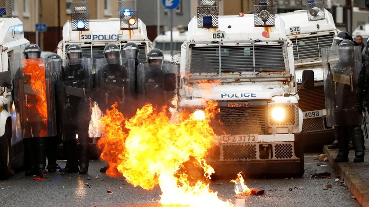 A fire burns in front of the police on the Springfield Road as protests continue in Belfast, Northern Ireland. Credit: Reuters Photo