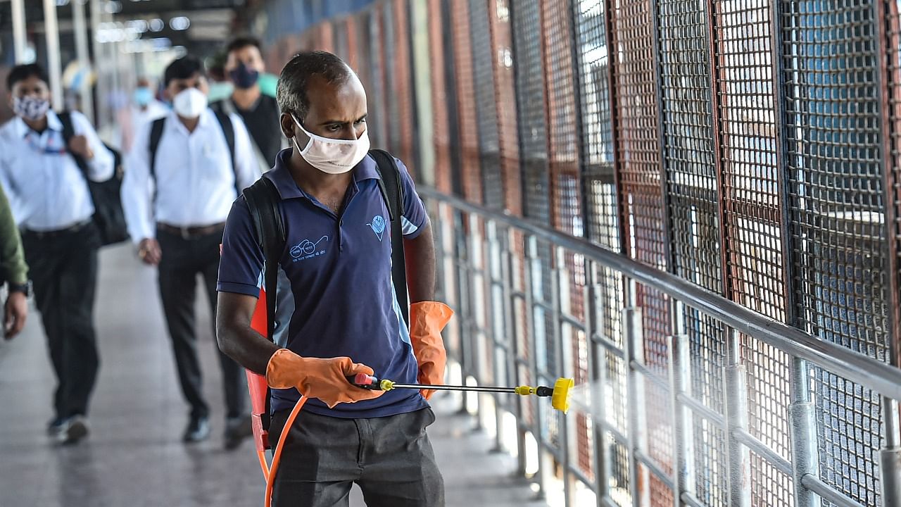 A workers carries out sanitization at New Delhi Railway Station, amid rise in coronavirus cases, in New Delhi. Credit: PTI.