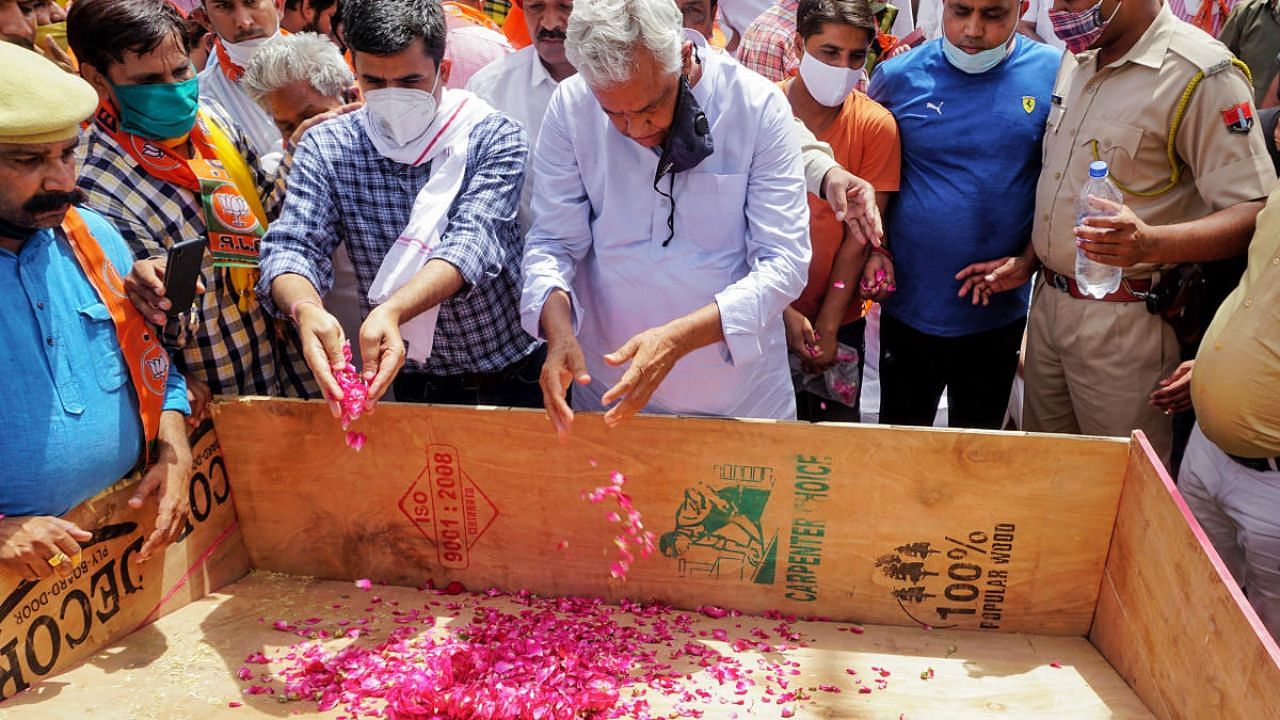 BJP MP Kirori Lal Meena pays tribute to priest Shambhu Sharma, who allegedly died due to trauma owing to pressure from local land mafias, during a protest dharna demanding justice for the deceased, in Dausa district. Credit: PTI photo. 
