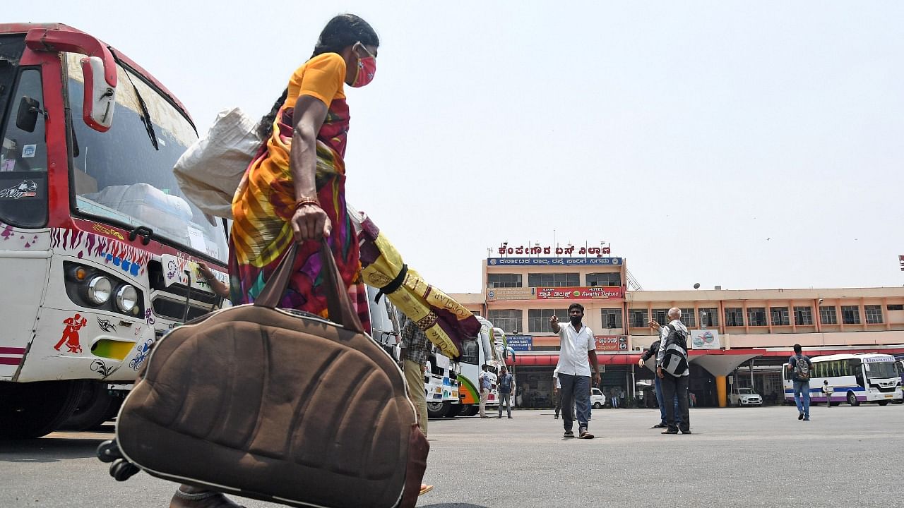 Passengers wait to board private buses during the indefinite strike called by RTC workers, at Kempegowda Bus Stand, Majestic in Bengaluru on Friday. Credit: DH photo/Pushkar V.