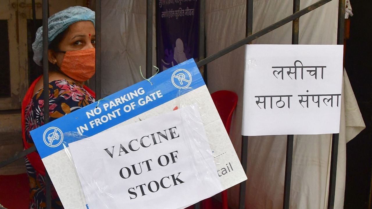 A woman stands next to a sign reading 'vaccine out of stock' at a Covid-19 coronavirus vaccination centre amidst rising Covid-19 coronavirus cases, in Mumbai on April 8, 2021. Credit: AFP Photo