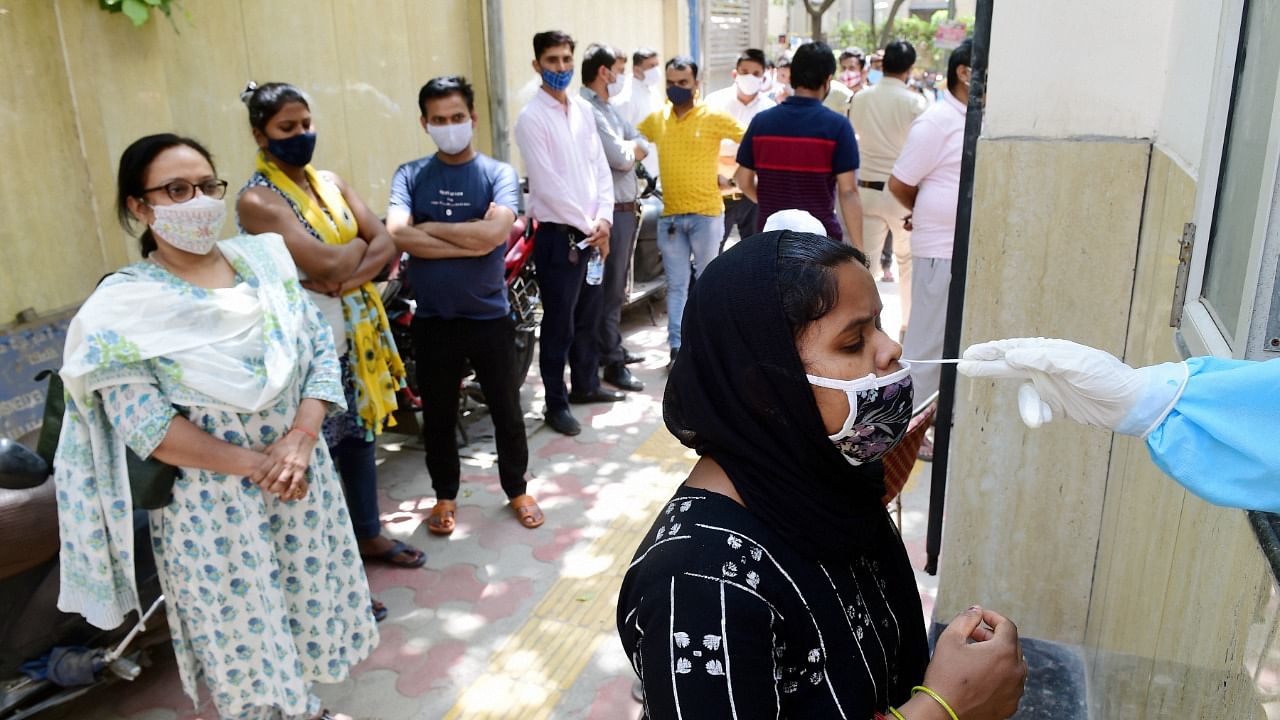 A health worker collects a nasal sample for Covid-19 test, amid coronavirus pandemic, in New Delhi. Credit: PTI Photo