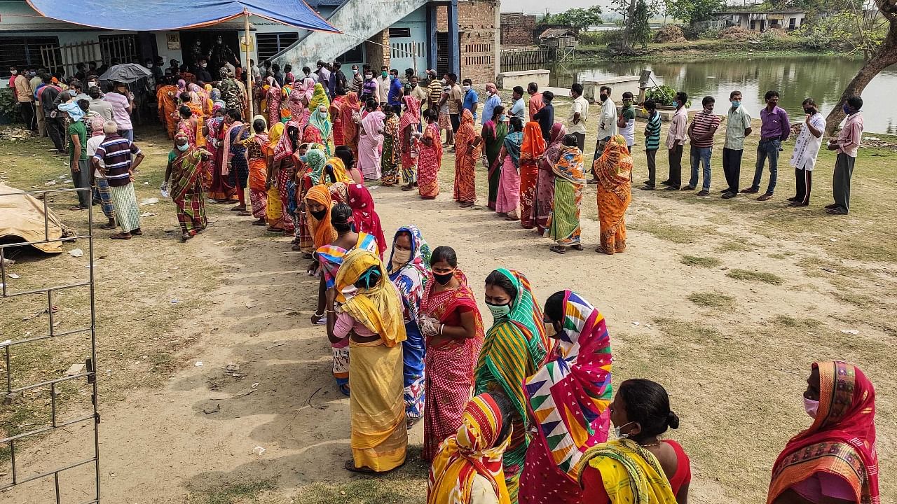 Voters stand in a queue at a polling station during the fourth phase of West Bengal Assembly elections, in South 24 Parganas district. Credit: PTI Photo
