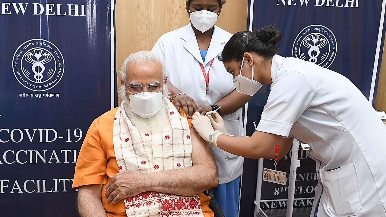 In this handout photograph taken on April 8, 2021 and released by the Indian Press Information Bureau (PIB), India's Prime Minister Narendra Modi (L) receives the second dose of the Covaxin Covid-19 coronavirus vaccine, at AIIMS hospital in New Delhi. Credit: AFP