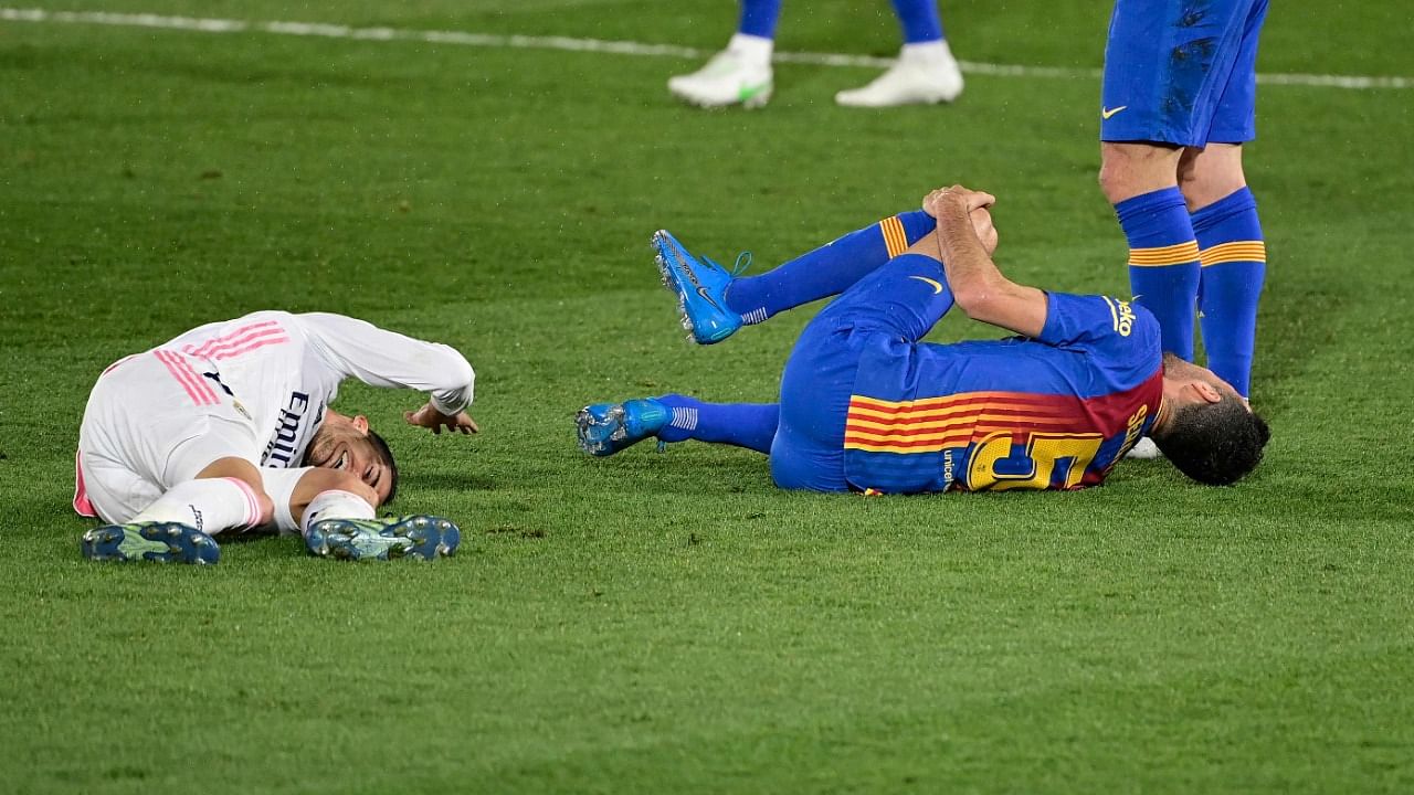 Lucas Vazquez (L)was involved in a heavy challenge with Barcelona's Sergio Busquets. Credit: AFP File Photo