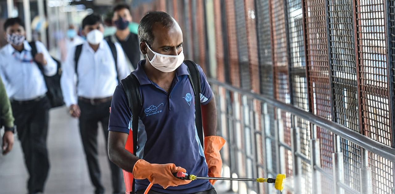 A worker carries out sanitisation at New Delhi Railway Station, amid rise in coronavirus cases, in New Delhi, Friday, April 9, 2021. Credit: PTI Photo