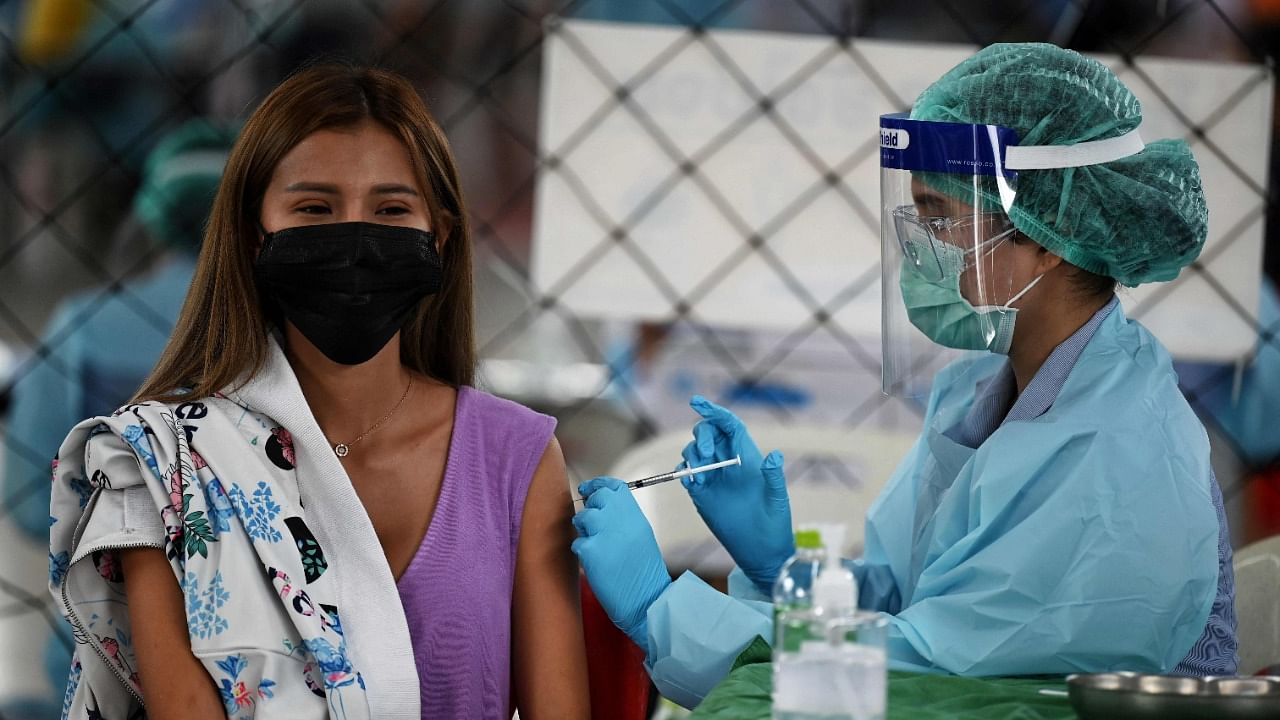 A medical personnel administers the CoronaVac vaccine, developed by China's Sinovac firm, to a woman, during a vaccination campaign to contain the spread of Covid-19 coronavirus cluster traced to entertainment venues, at Saeng Thip sports ground in Bangkok on April 8, 2021. Credit: AFP Photo