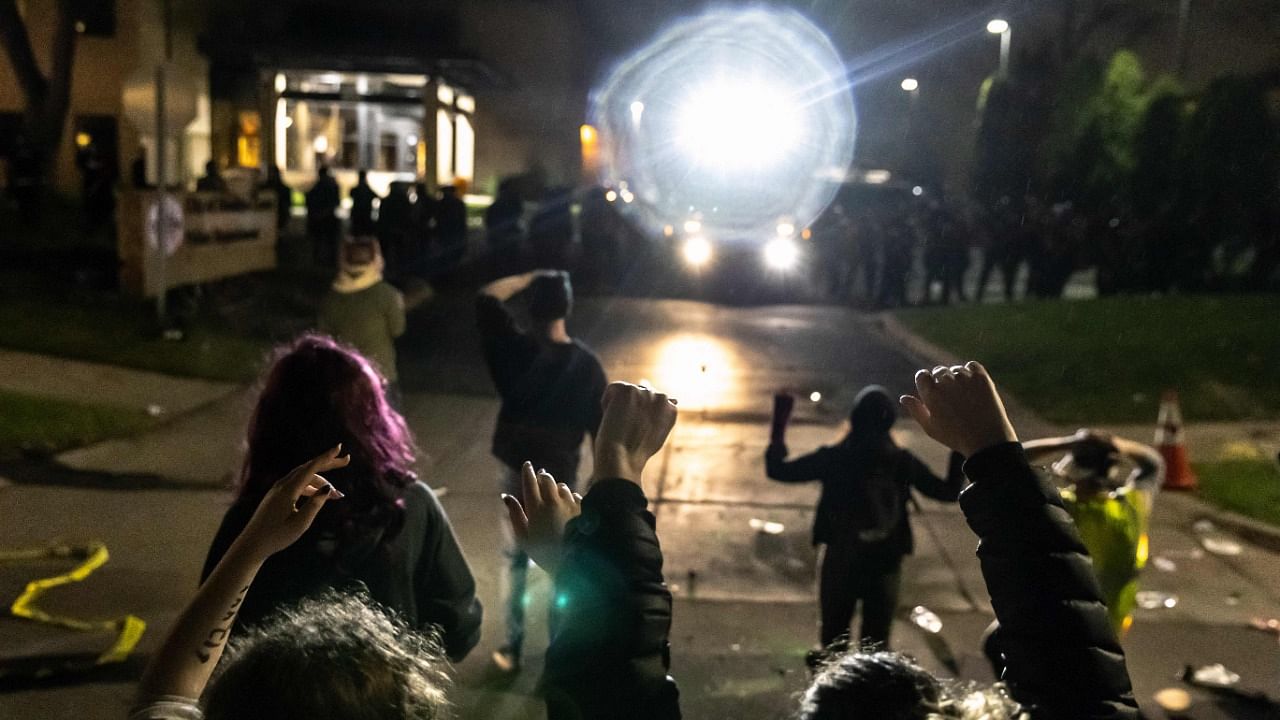 After nightfall, a few hundred protesters had gathered outside the suburban police department, guarded by hundreds of officers in riot gear. Credit: AFP Photo