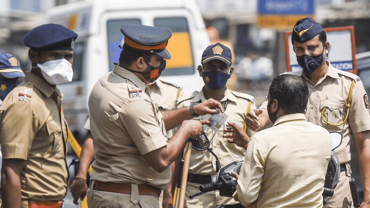 Police stop commuters at Western Express Highway as Maharashtra Government announced weekend lockdown due to surge in Covid-19 cases in Mumbai, Saturday, April 10, 2021. Credit: PTI Photo