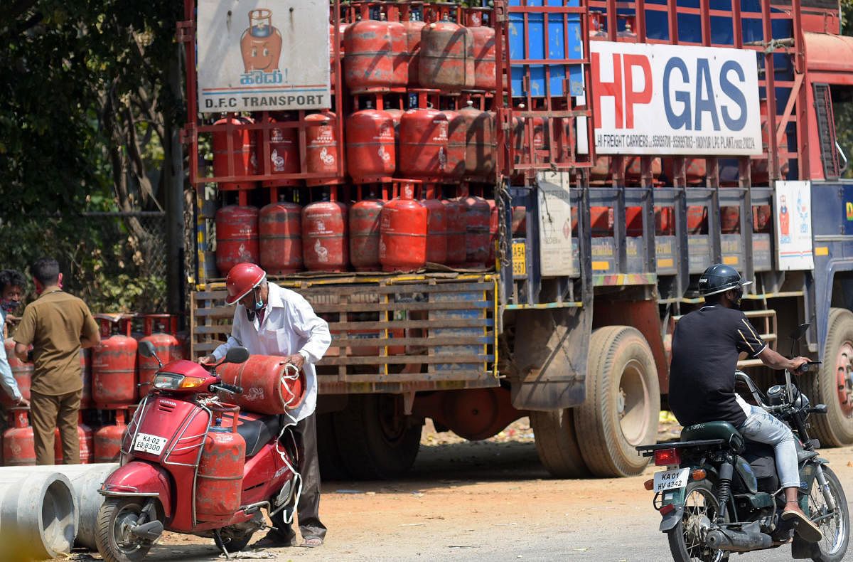 A delivery persons collect their orders of LPG gas cylinders for delivery in Bengaluru, Tuesday, Feb 16, 2021. Credit: DH Photo/Pushkar V