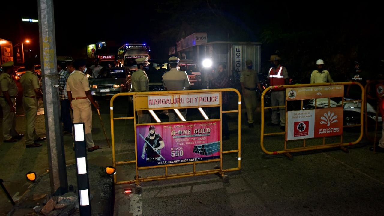 Police personnel at one of the check points during the enforcement of night curfew in Mangaluru. Credit: DH Photo