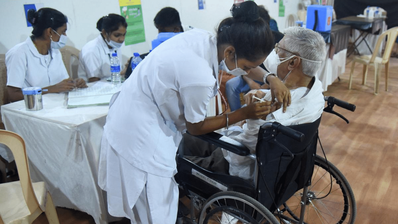 A medic vaccinates a person with a physical diaability during an inoculation drive, as coronavirus cases surge in Mumbai. Credit: PTI photo
