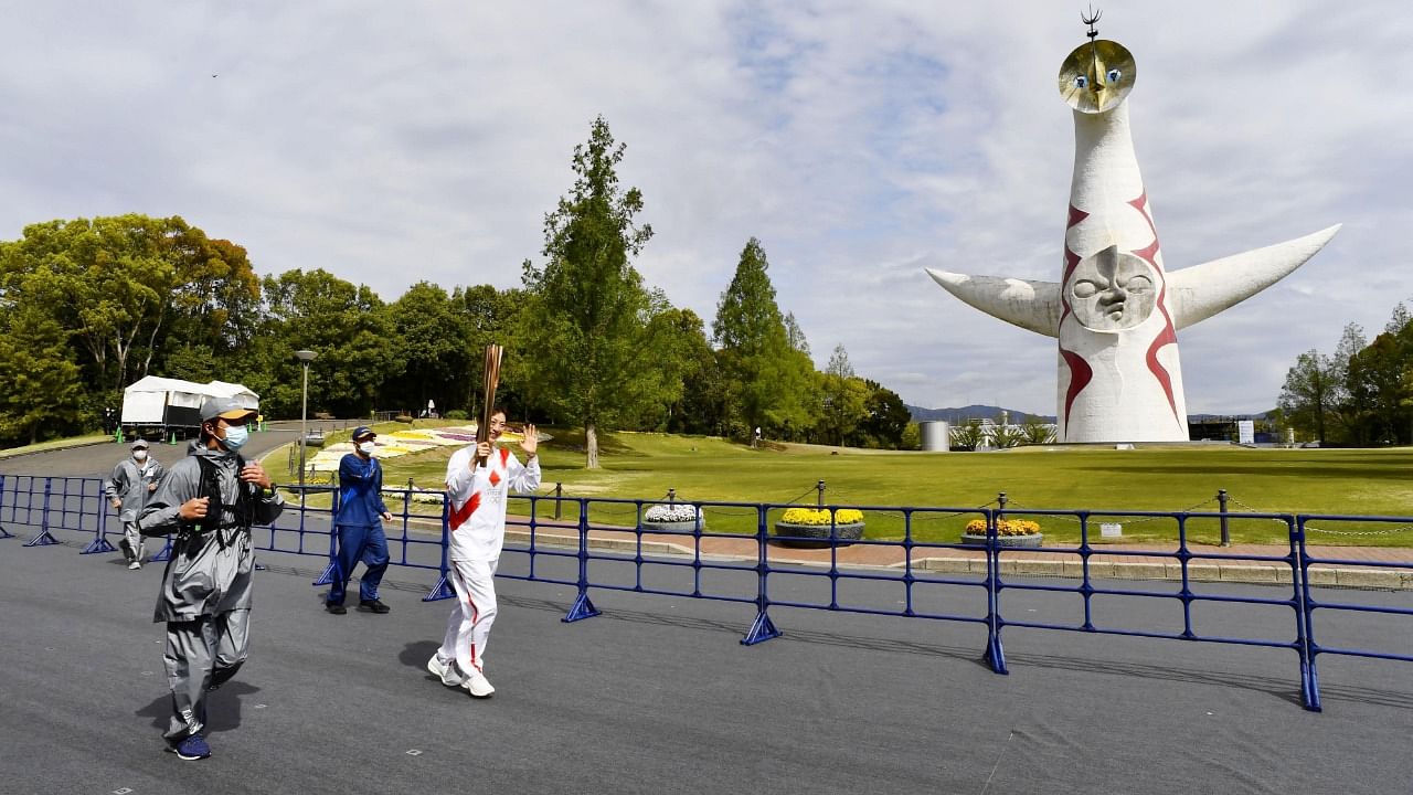 Former Japanese backstroke swimmer Aya Terakawa, a Tokyo 2020 Olympic torch relay runner, runs at the Expo '70 Commemorative Park without spectators instead of on public roads due to the coronavirus disease (COVID-19) outbreak in Osaka, western Japan April 13, 2021, in this photo released by Kyodo. Credit: Kyodo/via Reuters