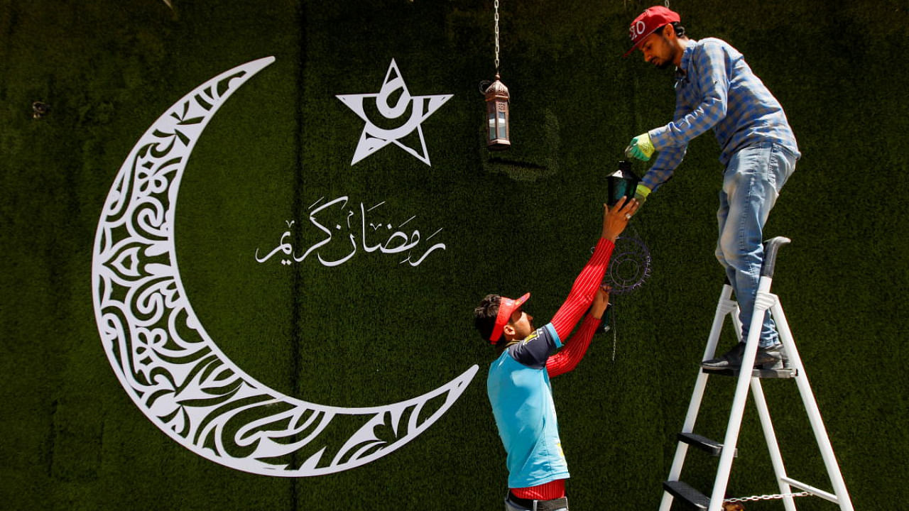 Workers hang traditional Ramadan lanterns, called "fanous", as part of preparations ahead of the holy fasting month of Ramadan, in Najaf, Iraq. Credit: Reuters Photo