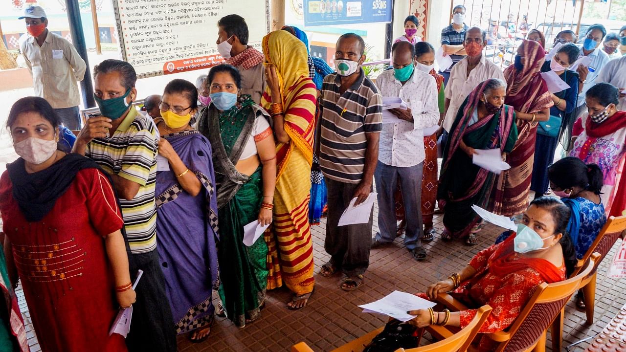 People wait in a long queue to receive Covid-19 vaccine doses, in Bhubaneswar. Credit: PTI photo