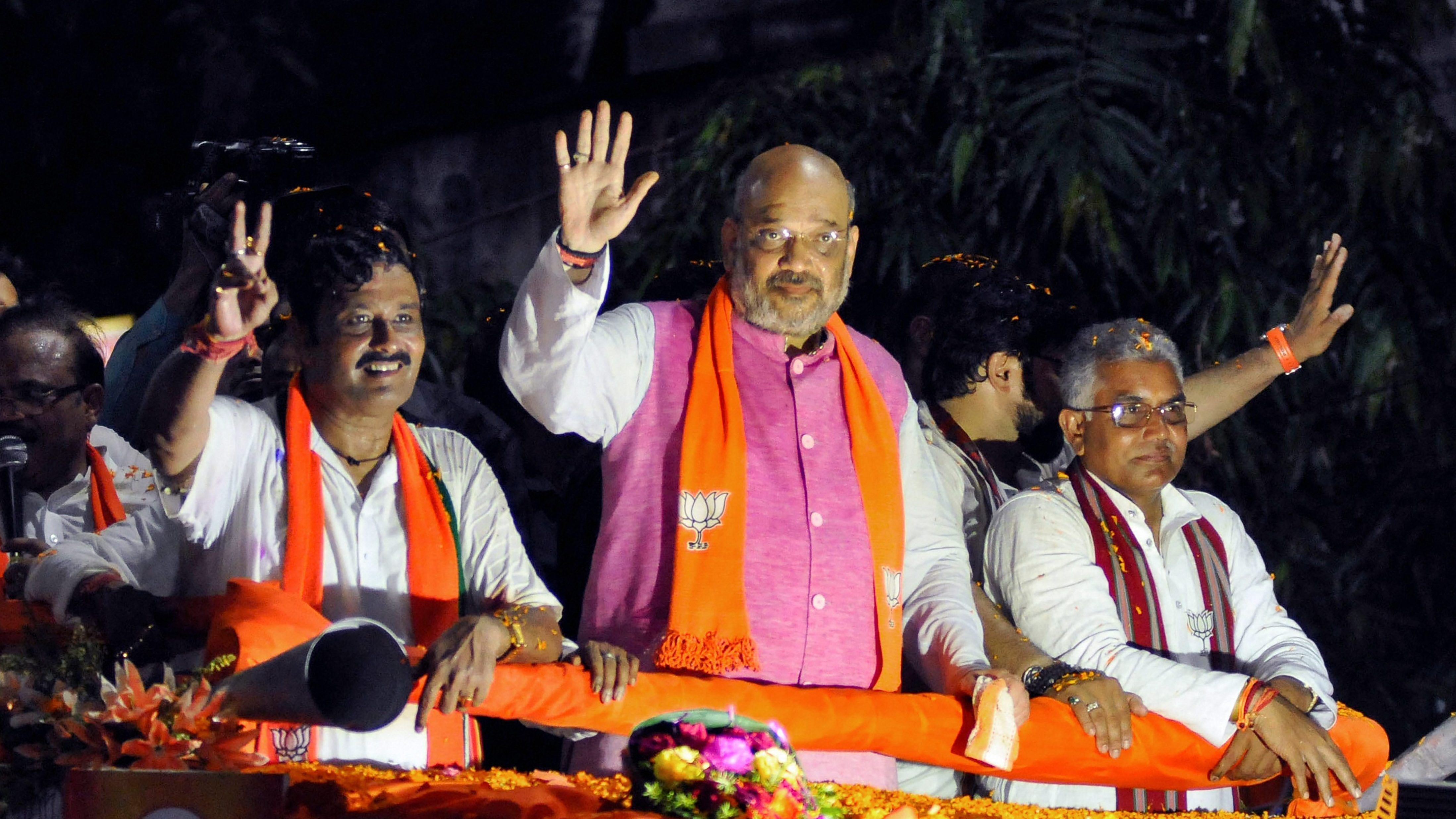 BJP National President Amit Shah during an election roadshow in support of party's north Kolkata seat candidate Rahul Sinha (L). Credit: PTI File Photo