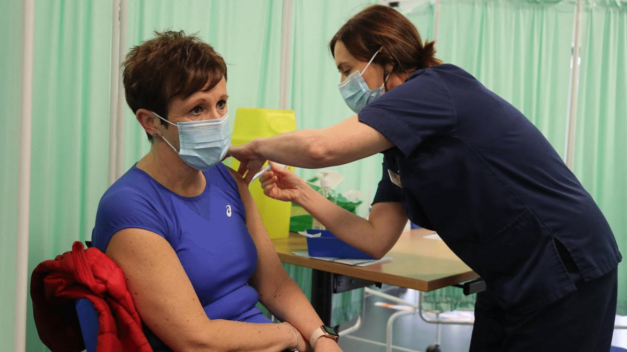 A healthcare professional administers an injection of Moderna Covid-19 vaccine at a vaccination centre at Ffwrnes Theatre in Llanelli, South Wales. Credit: AFP photo. 