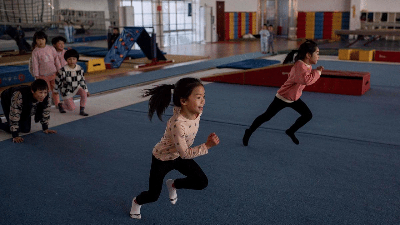 In this picture taken on January 12, 2021, young gymnasts train at the Li Xiaoshuang Gymnastics School in Xiantao, Hubei province. Credit: AFP file photo. 