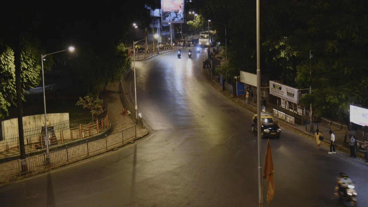 Commuters are pictured on a partially deserted road during a night curfew ahead of the scheduled weekend lockdown imposed by the state government amidst rising Covid-19 coronavirus cases in Mumbai. Credit: AFP Photo