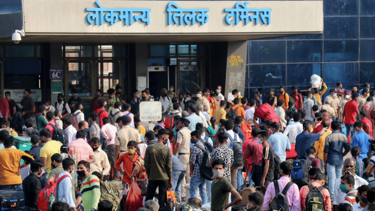 People wearing protective masks wait to enter the Lokmanya Tilak Terminus railway station, amidst the spread of the coronavirus in Mumbai. Credit: Reuters Photo