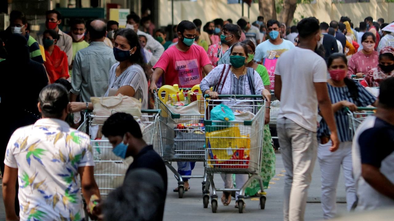  People push trolleys loaded with grocery items as others wait to enter a supermarket, amidst the spread of the coronavirus in Mumbai, India, April 14, 2021. Credit: Reuters Photo