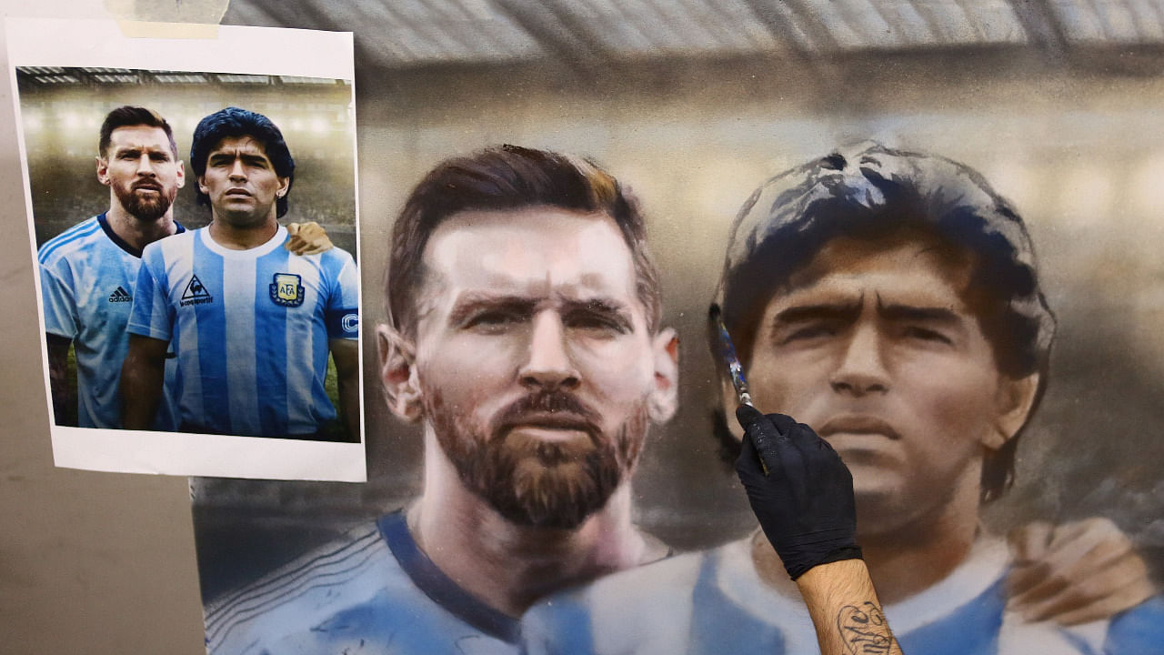 Argentine artist Maximiliano Bagnasco finishes a painting of soccer legend Diego Armando Maradona, and Barcelona's footballer Lionel Messi, at his workshop, in Buenos Aires. Credit: Reuters Photo