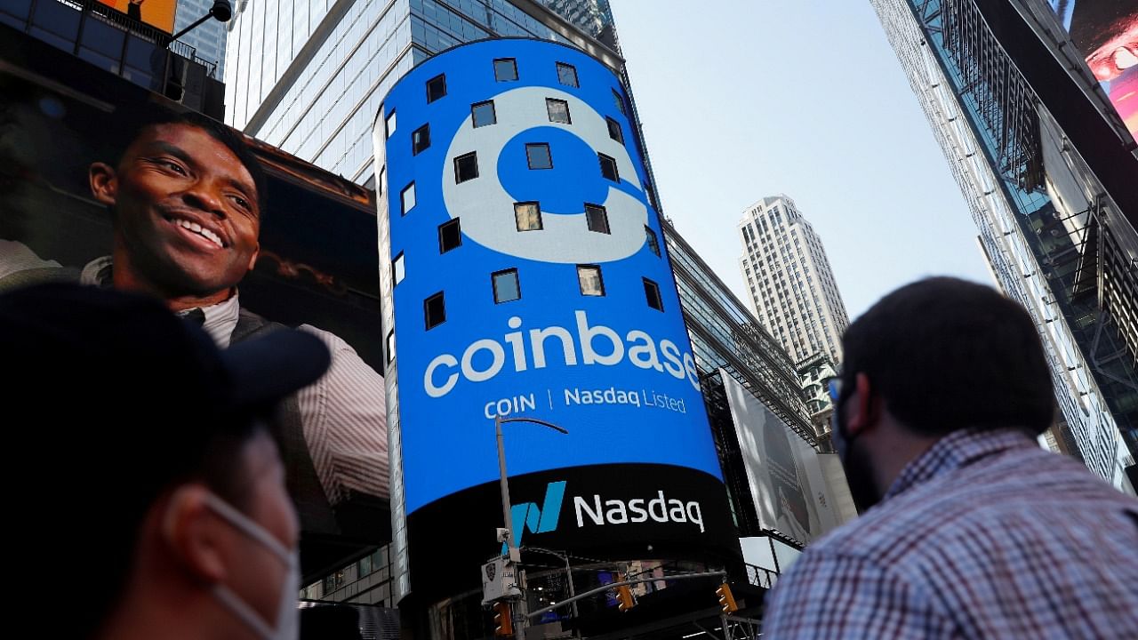 People watch as the logo for Coinbase Global Inc, the biggest US cryptocurrency exchange, is displayed on the Nasdaq MarketSite jumbotron at Times Square. Credit: Reuters file photo