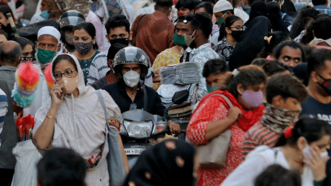 People wearing protective masks crowd a marketplace amidst the spread of Covid-19 in Mumbai. Credit: Reuters Photo