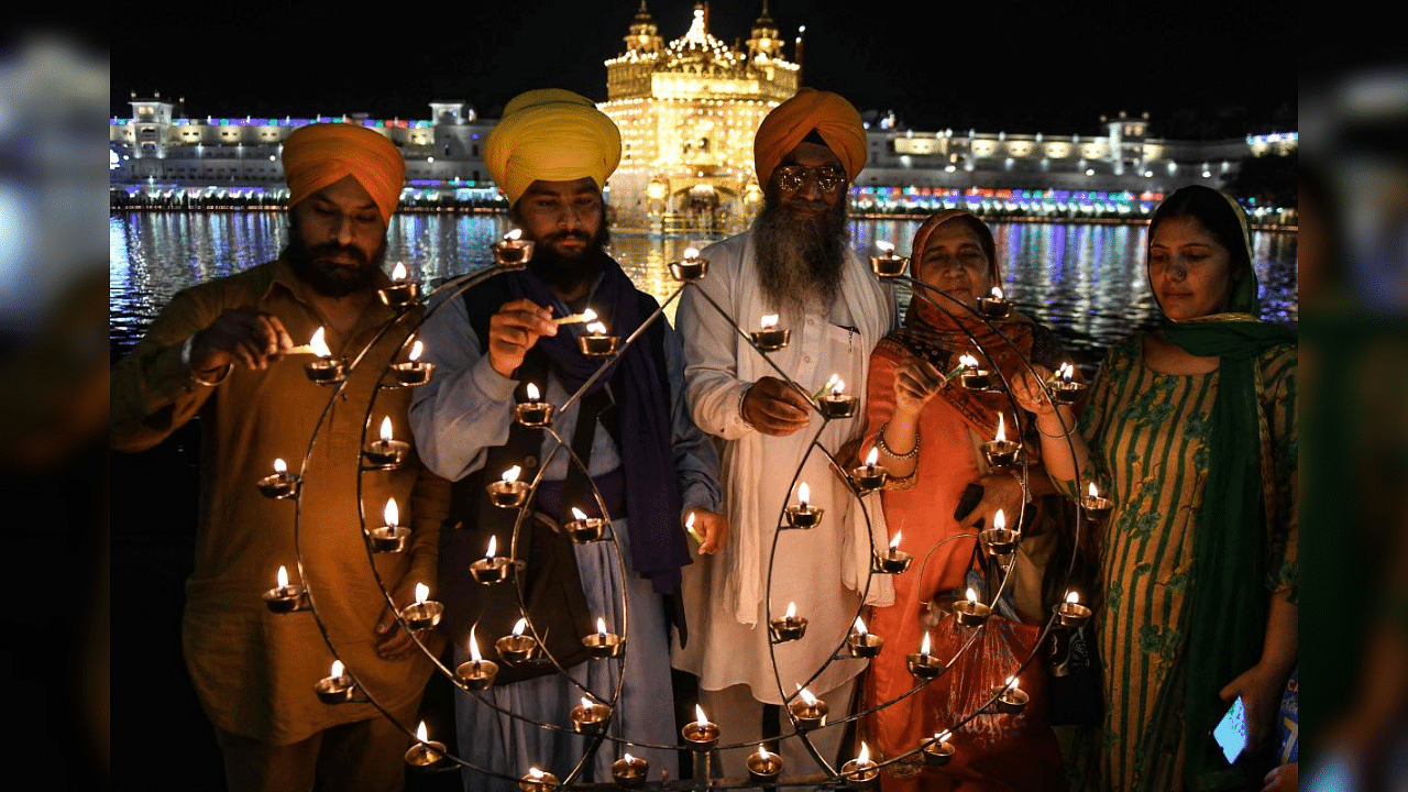 Sikh devotees light candles on the occasion of the Baisakhi festival at the Golden Temple, in Amritsar on April 13, 2021. Credit: AFP Photo