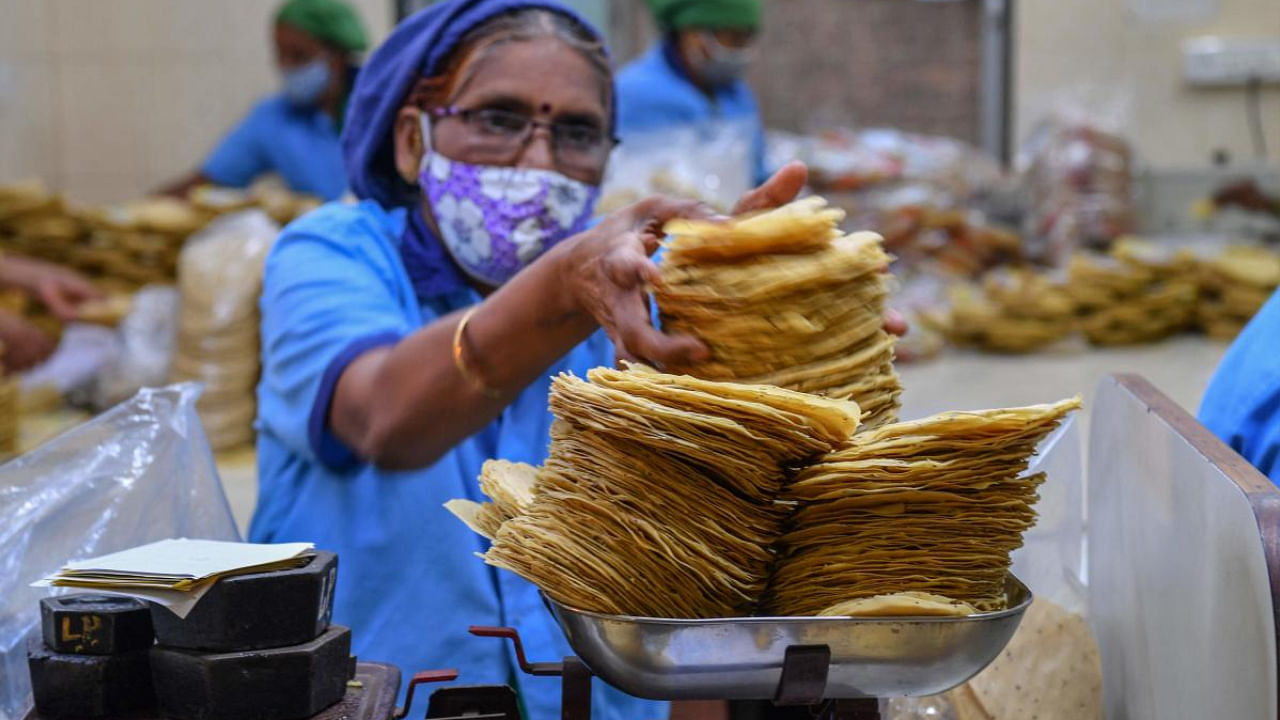 A staff member of Shri Mahila Griha Udyog, the organisation that produces the famous Lijjat Papad, weighs papadums at one of the organisation's facilities in Mumbai. Credit: AFP photo. 