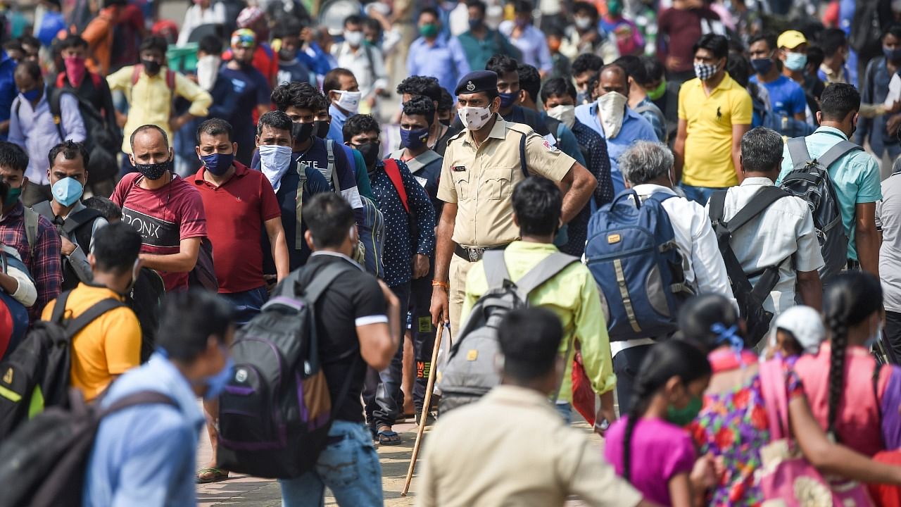 Passengers stand outside the Lokmanya Tilak Terminus to board outstation trains, amid the ongoing spike in Covid-19 cases in Mumbai, Wednesday, April 14, 2021. Credit: PTI Photo