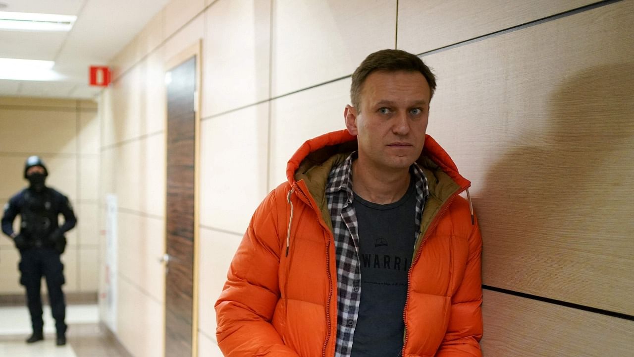 In this file photo taken on December 26, 2019 Russian opposition leader Alexei Navalny stands near law enforcement agents in a hallway of a business centre, which houses the office of his Anti-Corruption Foundation (FBK), in Moscow. Credit: AFP photo