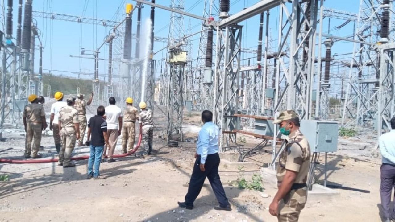 Fire and emergency services personnel extinguish the fire which broke out in a capacity transformer of the eighth unit of RTPS at Shakthinagar in Raichur. Credit: special arrangement